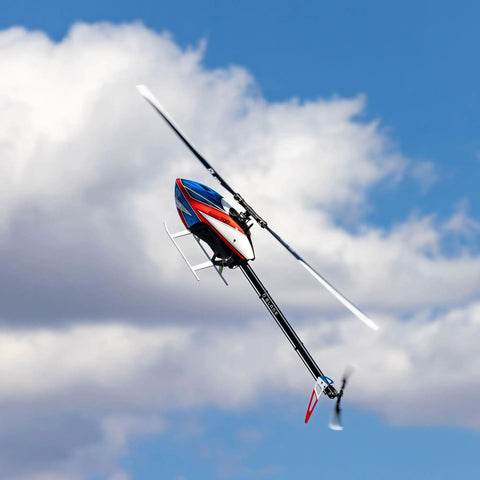 Fusion 700 Kit High Performance Super Combo with carbon fiber 700mm main rotor flying against a blue sky