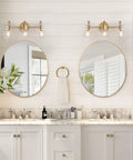 Gold 3 Light Vanity Light Fixture Over Mirror With Globe Clear Glass Shades in chic bathroom setting