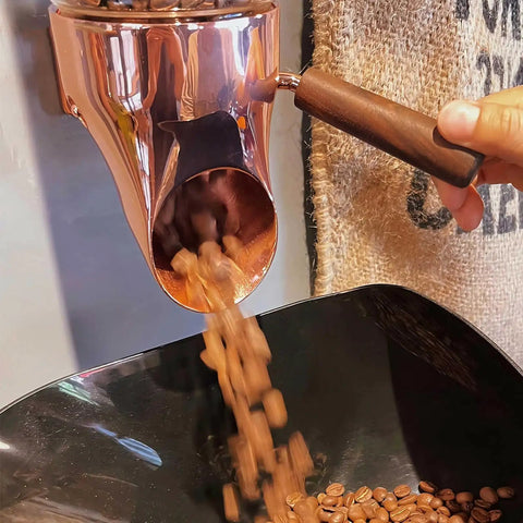 Wall Mounted Coffee Bean Dispenser With Adjustable Pour Spout And Airtight Lid keeps coffee beans flowing into a bowl.