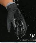 Black Warm Waterproof Winter Ski Gloves For Men And Women with water splashing off waterproof fabric in close-up view.
