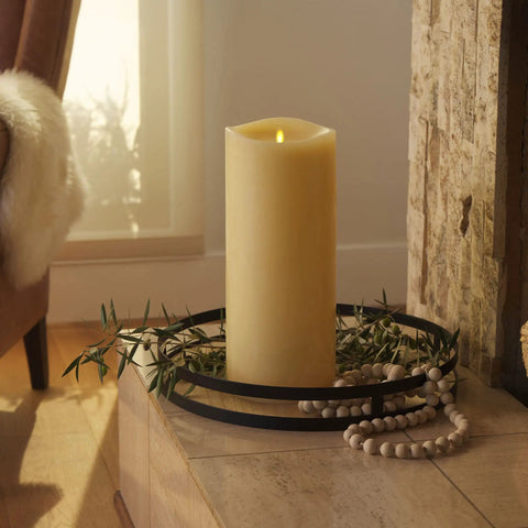 Cozy Ivory Grand Pillar Flameless LED Candle with Moving Flame on a mantel, surrounded by beads and greenery, 6.25x15 inch