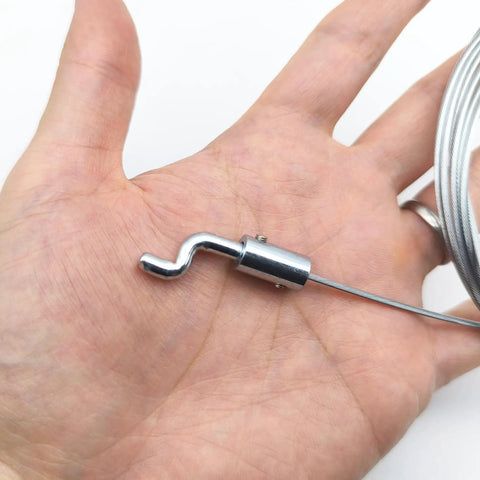 Close-up of Universal Throttle Cable Repair Kit with Z-bend end, flexible steel wire in a hand, for lawn mower control.