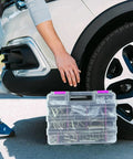 Purple 50-Compartment Double-Sided Tools Organizer Box With Removable Dividers near a car tire, used for small parts storage.