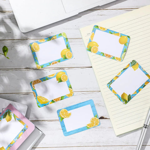 Lemon Themed Classroom Name Tags Set Of 48 Self Adhesive Desk Nameplates with varying lemon patterns on a notebook and desk.