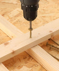 Heavy Duty 6 Inch Lag Screws Kit For Outdoor Wood And Structural Fastening Bronze Carbon Steel Washer Head Rust Resistant Epoxy Coated T30 Star Bit 96 Pieces 4 Lb Total Weatherproof Long Lasting Exterior Screws in use, showing drill and screw installation in wood.