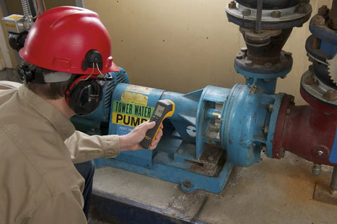 Worker inspecting Tower Water Pump with Rock Solid LED Stroboscope Featuring 30 To 300000 FPM Flash Rate And Knockout Brightness.