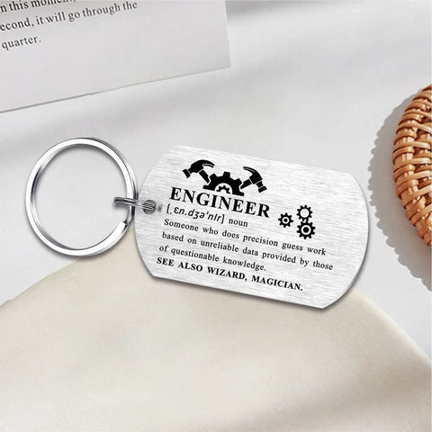 Engineer Definition Keychain Gift For Men And Women on fabric, 50x28mm stainless steel with humorous engraving and gear design.