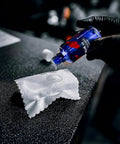 CARPRO CQUARTZ UK 3.0 ceramic coating bottle dispensing onto white microfiber cloth (close-up)