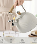 Stovetop Tea Kettle 2.5 Quart Whistling Kettle With Stainless Steel Body Creamy White Finish Wood Pattern Folding Handle pouring tea