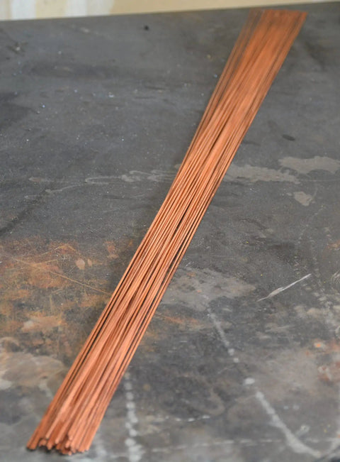 1/16 Inch ER70S-6 Mild Steel TIG Filler Rods on a workbench, 1 Lb Pack For Welding Mild Steel, Built Tough And Smooth Flow.