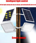 Heavy Duty Double Head Solar Flood Lighting With Remote And IP67 Waterproof Shield mounted on a wooden post with solar panels.