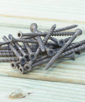 DSVT4MB Deck-Drive DSV Wood Screw 10 x 4 Inch Flat Head T-25 with Quik Guard Tan scattered on wood surface