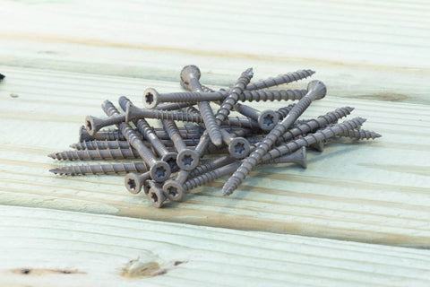 DSVT4MB Deck-Drive DSV Wood Screw 10 x 4 Inch Flat Head T-25 with Quik Guard Tan scattered on wood surface