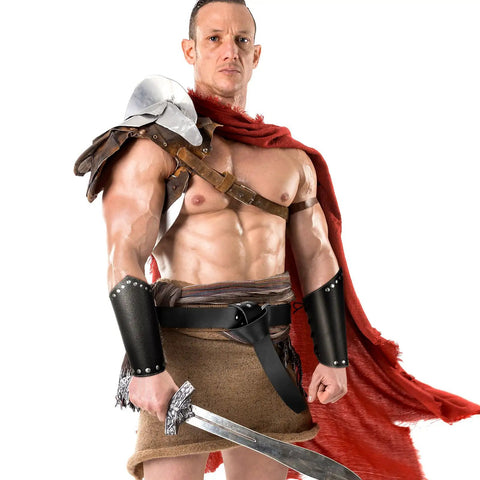 Man wearing Medieval Viking Belt And Faux Leather Arm Guards Bracers Set 3 Piece For Cosplay with sword and red cape