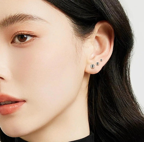 Woman wearing Five Pair Silver Stainless Steel Ball Stud Earrings Set For Women Hypoallergenic Round Studs In 3mm To 7mm Sizes For Everyday Wear And Gift Giving Tarnish Resistant Jewelry Kit Essentials.