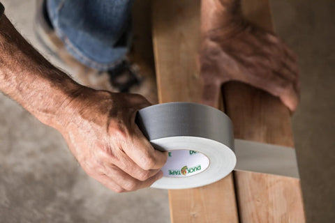 Person using Duct Tape 1.88 Inch By 10 Yard Silver All Purpose Quick Fix Tape for temporary repairs on wooden surface