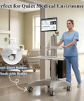 Adjustable Height Rolling Standing Desk With Rock Solid Monitor Mount And Smooth Keyboard Tray in a medical setting with a user.