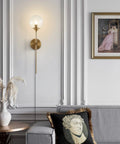 Gold Globe Wall Sconce Plug In Mid Century Modern Long Arm Light With Bubble Glass Shade in elegant living room setting.