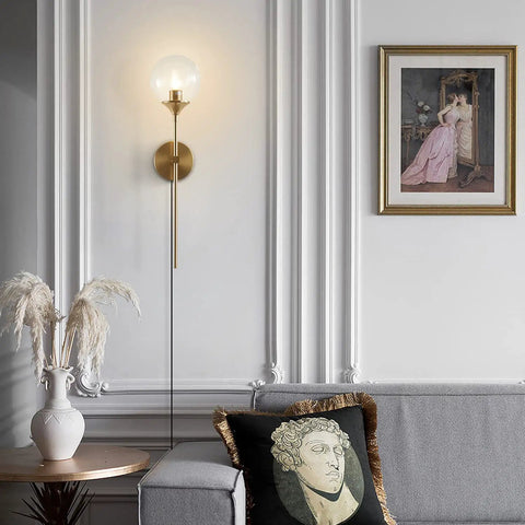 Gold Globe Wall Sconce Plug In Mid Century Modern Long Arm Light With Bubble Glass Shade in elegant living room setting.