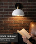 Industrial Dome Wall Sconce, White, 180° Adjustable Vintage Wall Light illuminating a reading nook on a brick wall.