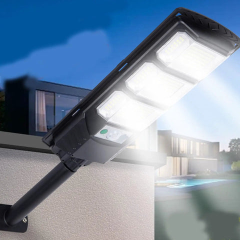 JUDYSSY 400W Super Bright Led Beads Commercial Solar Flood Lights mounted on a wall illuminating a courtyard.