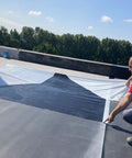 Two roofers laying down Heavy Duty 45 Mil EPDM Roofing Membrane 10 Feet By 200 Feet Roll for flat roofs.