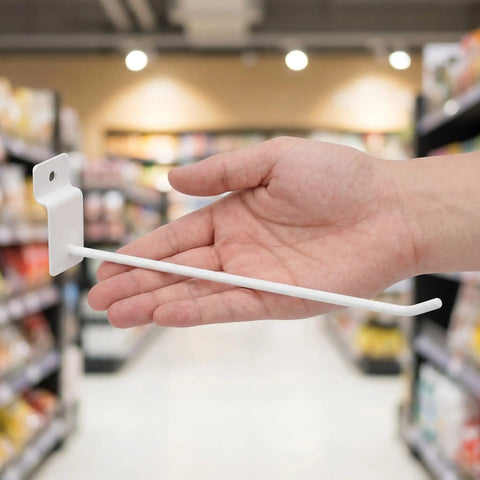 Hand holding white hook from 20 Pack Slatwall Hooks For Garage Storage And Shop Shelves, Heavy Duty Iron With 4mm Rod Thickness