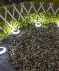 8 Pack Solar Ground Lights With 20 Lumen White And Color LED Disk Lights Multi Color Modes illuminating rocks by fence