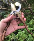 Heavy Duty Garden Pruning Shears With Japanese SK4 High Carbon Steel Blade in hand, wood grain handle, cutting a branch