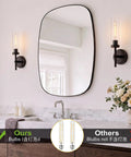SANTOSTOCK Black Wall Sconces Set of Two in modern bathroom, showcasing clear glass shades and a stylish oval mirror.