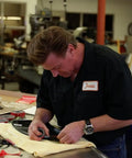 Person applying Super Strength Automotive Tape 03609 on a car part in a workshop setting.