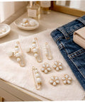 Eight Piece Pearl Waist Tightener Pins With Secure Locking Buckle System Fixes Loose Jeans And Skirts Instantly No Sew Hidden Dress Clips on fabric with denim and bag.