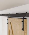 Wall-mounted 6.6Ft Box Rail Sliding Barn Door Hardware Kit Alloy Steel with ball bearing rollers installed above wood door