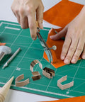 Person using All In One Leather Corner Punch Kit With 18 High Speed Steel Dies 6 Sizes And 3 Shapes for leather crafting on mat