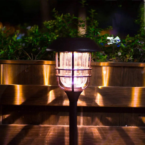 Lit Solar Path Lights 4 Pack Waterproof Metal Outdoor Lights with Glass and Stainless Steel Housings illuminating walkway by night