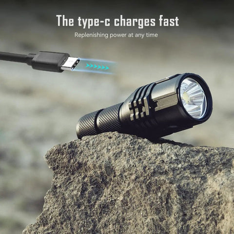 Ultra Bright EDC Flashlight 13000 Lumens, Rechargeable Pocket Light For Camping And Hiking, Emergency Prep, USB C Recharge, Compact 4.5 Inch Size, Long Lasting Battery on rock with USB-C charging cable.