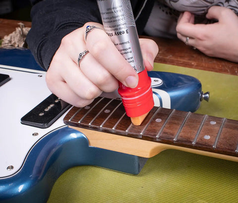 Complete Guitar Care Kit And Clean Polish Set With Fretboard Conditioner Three Premium Microfiber Cloths Zero Grease Formula applied on guitar fretboard.