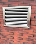304 Stainless Steel Vent Grille Access Panel mounted on brick wall, featuring louvered design and no sweat mounting.