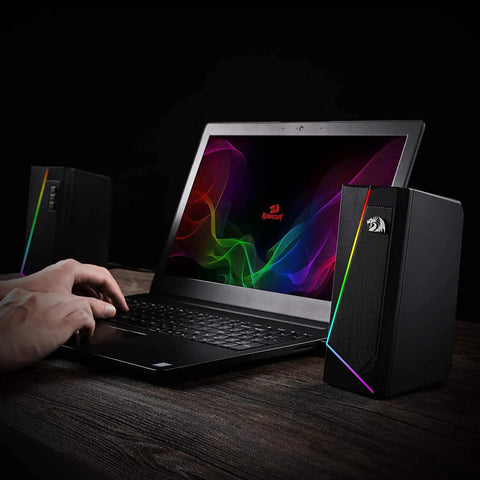 GS520 RGB Desktop Speakers 2.0 Channel PC Computer Stereo System with 6 LED Modes next to laptop on wooden desk