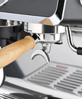 Close-up of 58mm portafilter with wooden handle on Fully Automatic Espresso Machine With Badass Burr Grinder And Hella Smooth Pulls.
