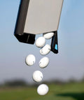 Close-up of golf balls being released from a Golf Ball Shag Portable Ball Picker, Compact Practice Essential, outdoors.
