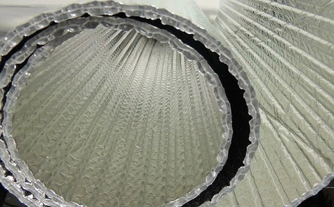 Close-up of Spiral Duct Wrap Reflective Insulation For HVAC 12 Inch By 5 Foot R8 To R24 with foil layers and bubble core.