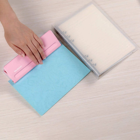 Hand using pink adjustable 6 hole punch for planners and binders, durable metal puncher with 6 sheet capacity, fits A4 A5 A6 and pocket notebooks.