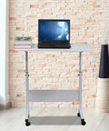 Kick Back And Crush Your Daily Grind With This Adjustable Standing Computer Desk Featuring Smooth Locking Wheels And A Foldable Rolling Laptop Table Built For Cozy Living Room Setups with laptop, books on white top.