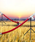 Grab And Go Portable Grain Pumping Suction Auger Screw Conveyor for small grains in a field at sunset, with red rubber hose.