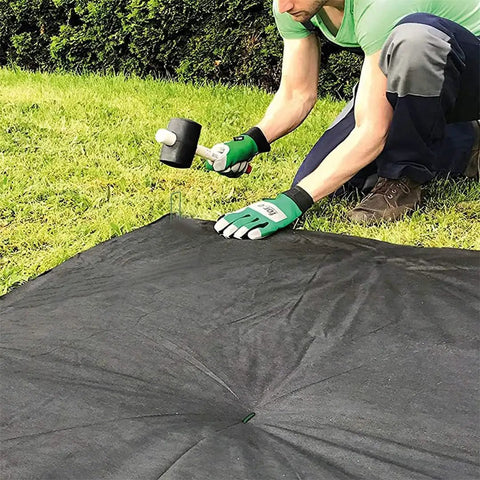 Person installing U Shaped Galvanized Steel Ground Pins Garden Stakes And Staples For Landscape Netting And Ground Sheets