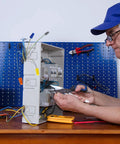 Side view of a technician wiring an open electrical panel with colorful insulated wire connectors (180 pcs) and tools nearby