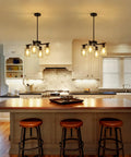 Sleek Modern Black Four Light Farmhouse Chandelier Featuring Crisp Cylindrical Glass Shades Fully Adjustable Height Industrial Pendant Fixture in a stylish kitchen.