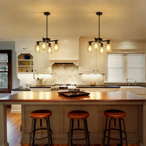 Sleek Modern Black Four Light Farmhouse Chandelier Featuring Crisp Cylindrical Glass Shades Fully Adjustable Height Industrial Pendant Fixture in a stylish kitchen.