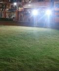 Solid Solar Flood Light With A Kickin Brightness Setup And Zero Sweat Weather Proofing For Your Patio Decks And Yard Upgrades Including Remote Controls And Hella Efficient Led Lighting illuminating a grassy area at night.